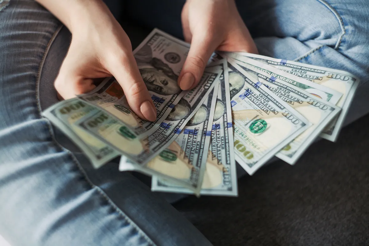Person counting money to plan a move-out budget